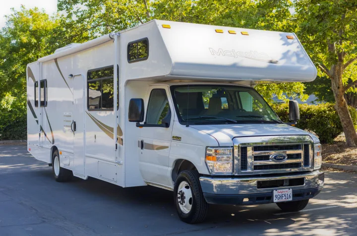 White Ford Majestic Class C RV rental parked outdoors, ready for your next adventure.. Thor Majestic 2015