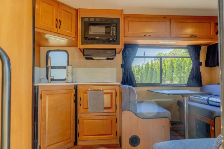 Step inside this RV rental's well-equipped kitchen with a microwave and sink, and a cozy dining area.. Thor Majestic 2015