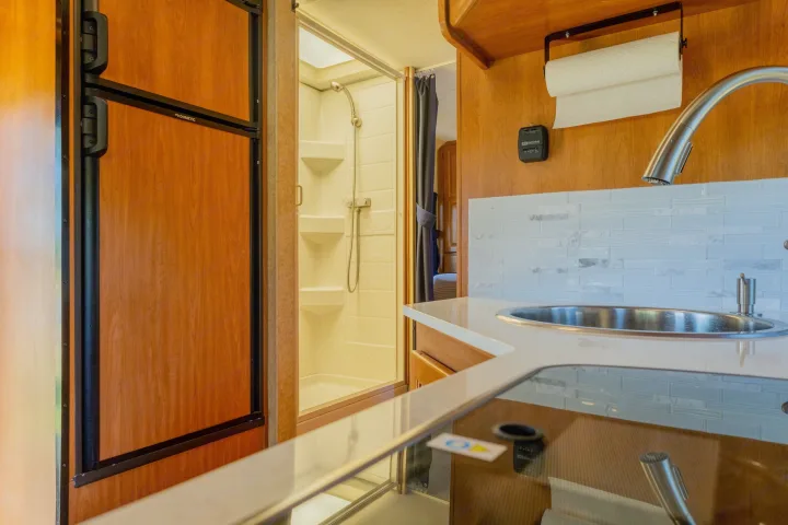 This RV rental's compact interior includes a kitchen with sink, Dometic fridge, and a functional shower, perfect for your adventures.. Thor Majestic 2015