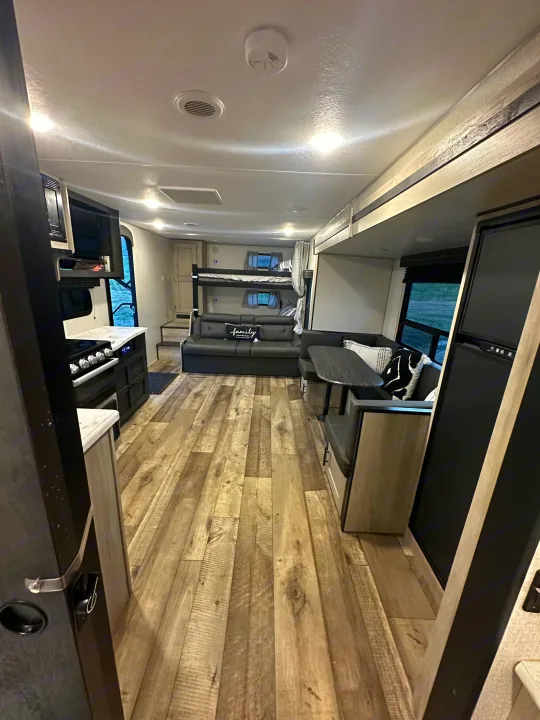Spacious rv rental interior featuring kitchen, dining, bunk beds, and a comfy sofa, perfect for family adventures.. Connect SE 2022