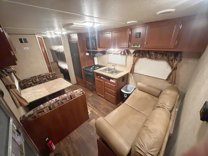 Inside a bright RV rental: kitchen, dining, sofa, and bunks.. Crossroads RV Z-1 2013