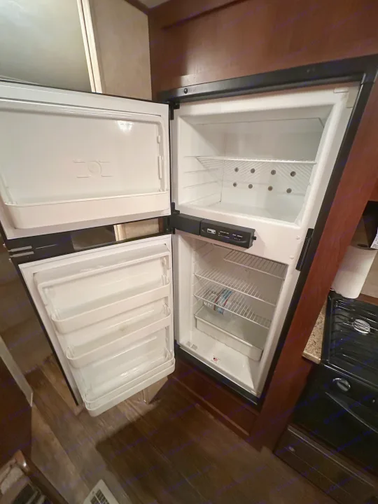 Clean, open refrigerator and freezer in this RV rental's kitchen. Ready for your trip's supplies!. Crossroads RV Z-1 2013