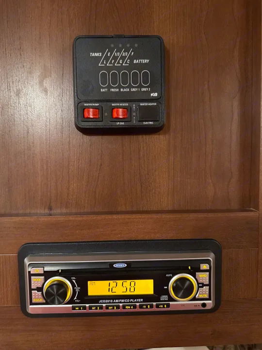 RV rental interior: KIB control panel for tanks & water heater controls, and Jensen JCD2010 AM/FM/CD stereo.. Crossroads RV Z-1 2013