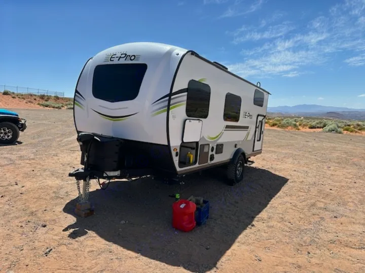 This E-Pro rv rental travel trailer is set for desert adventures, parked on sandy ground under a clear sky.. Forest River Flagstaff E-Pro 2023