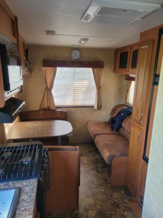 RV rental interior showing a compact kitchen, dinette, and living area with a sofa. Ready for travel!. Starcraft Autumn Ridge 2011