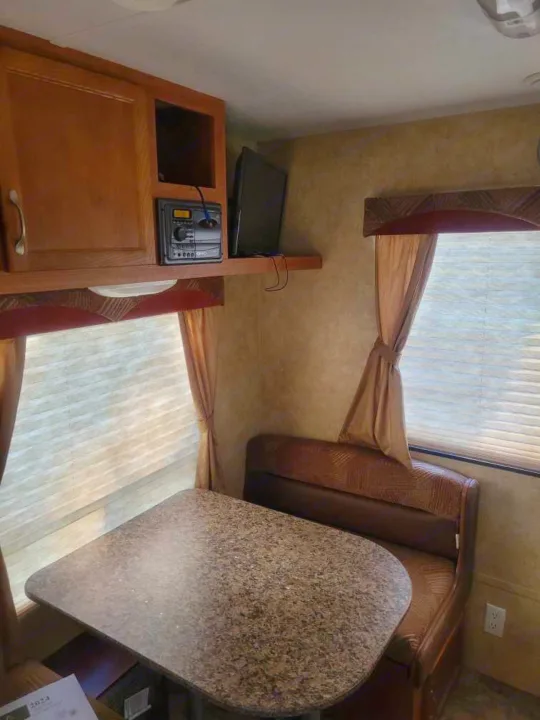 RV rental interior features cozy dinette seating, entertainment system, and large windows. Perfect for your next adventure.. Starcraft Autumn Ridge 2011