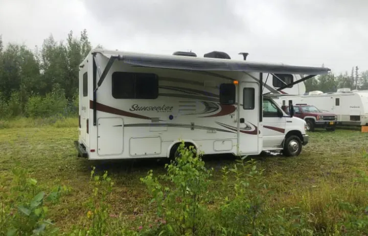 Sunseeker RV rental with awning extended, parked in a grassy area. Ideal for camping and travel.. Forest River Sunseeker 2016