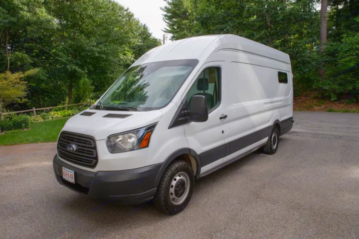White Ford Transit camper van, perfect for your next RV rental adventure, parked on a paved drive.. Ford Transit 2018