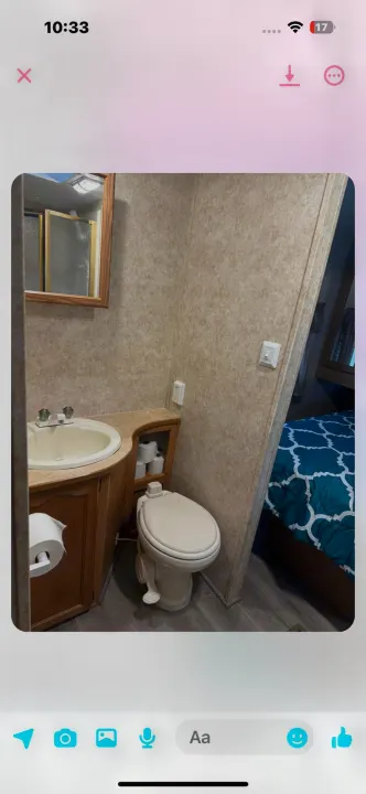 View of a functional RV bathroom with a toilet, sink, and a mirrored shower area visible. Perfect for your next rv rental.. Keystone RV Cougar 2006