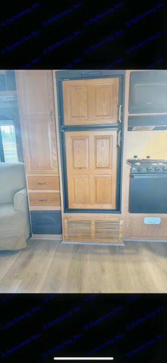 RV rental: Clean RV interior with full kitchen, Dometic fridge, Sylvania microwave, oven, and wood cabinets.. Keystone RV Cougar 2006