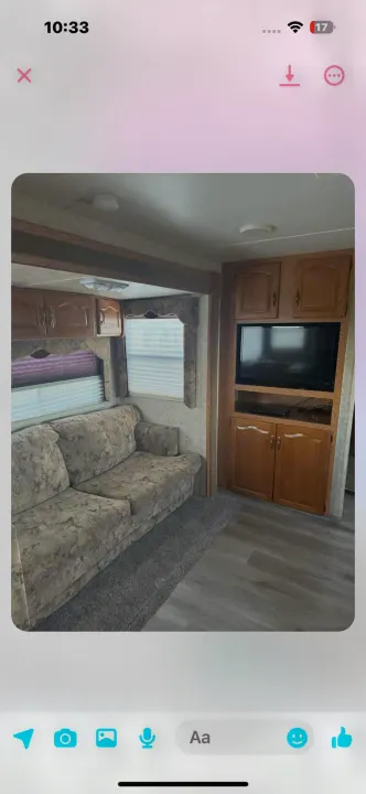 Cozy RV rental interior featuring a floral sofa, wood cabinets, TV, windows with blinds, and durable flooring. Ready for travel!. Keystone RV Cougar 2006
