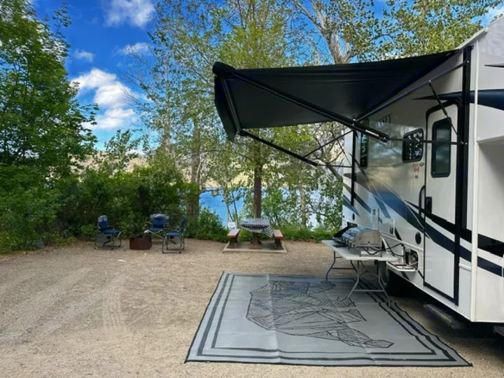 RV rental at a lakefront campsite: features an extended awning, grill, chairs, and picnic table for outdoor living.. Entegra Coach Odyssey SE 22C 2024