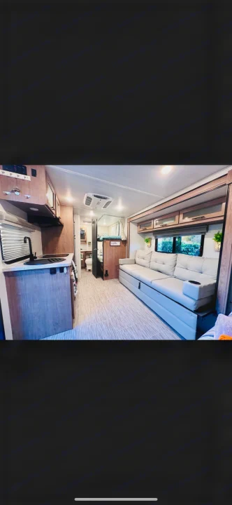 Spacious RV rental interior featuring a modern kitchen, living area with sofa, bunks, and bathroom. Perfect for travel.. No Boundaries 19.8 2021
