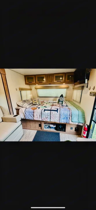 Comfortable RV rental interior: bed, cabinets, TV, seating area. Ideal for travel.. No Boundaries 19.8 2021