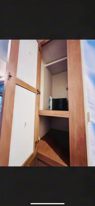 RV rental: spacious open closet with wood shelves, hanging rod, and textured walls, ready for travel storage.. No Boundaries 19.8 2021