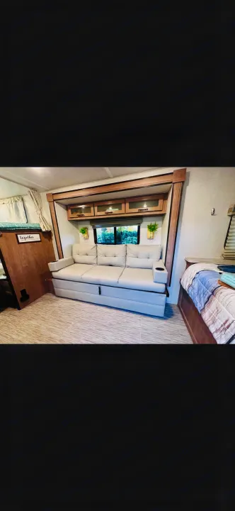 RV rental: Bright RV interior featuring a light sofa, windows, overhead cabinets, and a convertible bed on the left.. No Boundaries 19.8 2021