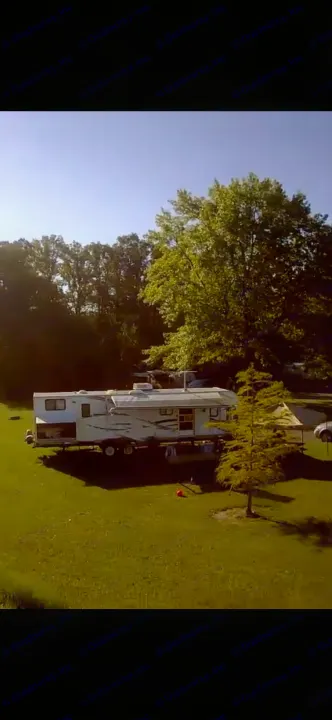 RV rental parked in a sunny campground. Enjoy outdoor leisure with this spacious travel trailer.. Forest River Wildwood 2012