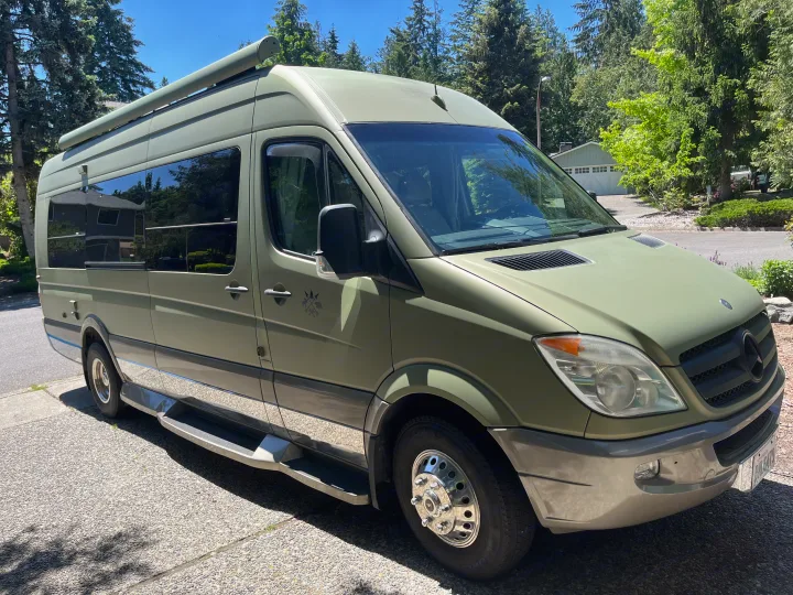 Olive green Mercedes-Benz Sprinter RV rental, featuring an awning and chrome running boards.. Other Other 2012