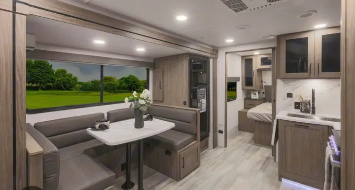 Modern RV rental interior showcasing a cozy dinette, functional kitchen, and compact bedroom area.. Alliance Delta 251BH 2024