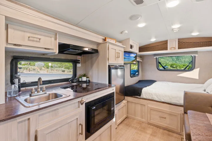 Discover this bright, compact RV rental interior. Features a full kitchen, sleeping area, and storage for easy travel.. Rockwood G19QB 2021