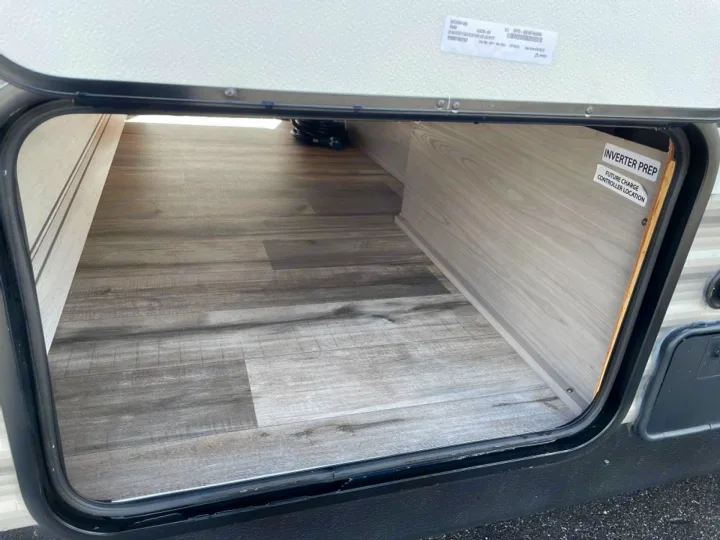 Open RV rental pass-through storage with wood-look interior. Labels indicate 'Inverter Prep' & 'Future Charge Controller Location'.. Coleman Lantern LT 274BH 2024