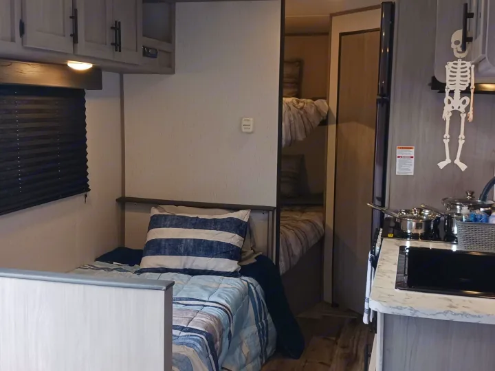 Cozy RV rental interior showcasing compact living spaces with a bed, bunk beds, kitchen, and storage for your adventure.. Coleman Lantern LT 274BH 2024