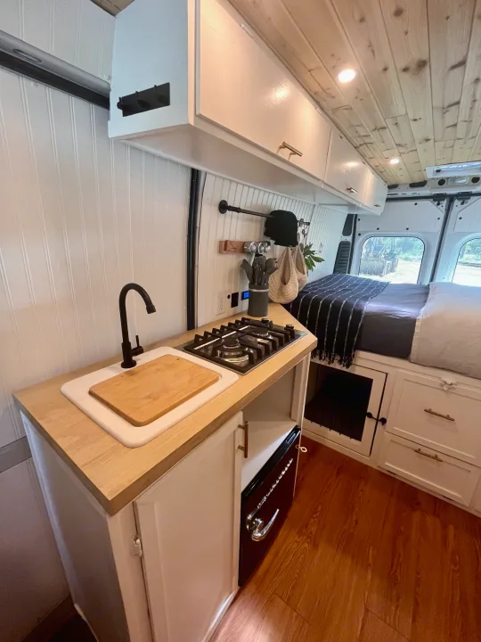 Modern RV rental: custom kitchen with sink, stove, wood counters, bed & storage. Perfect for van life.. Dodge B Van 2015