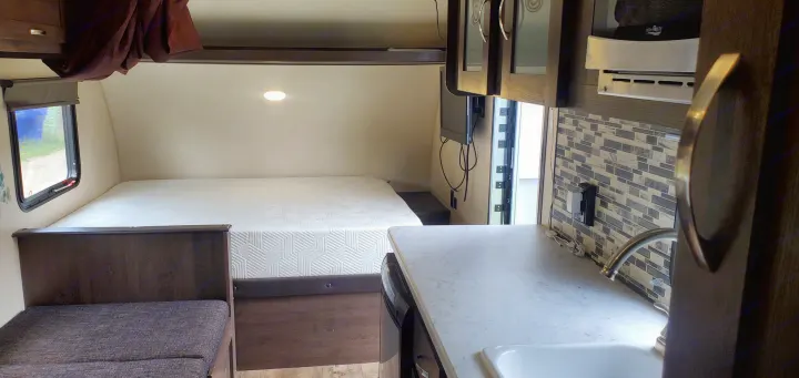 Cozy RV rental interior with bed, compact kitchen, and dinette seating visible.. Forest River Salem FSX 2019