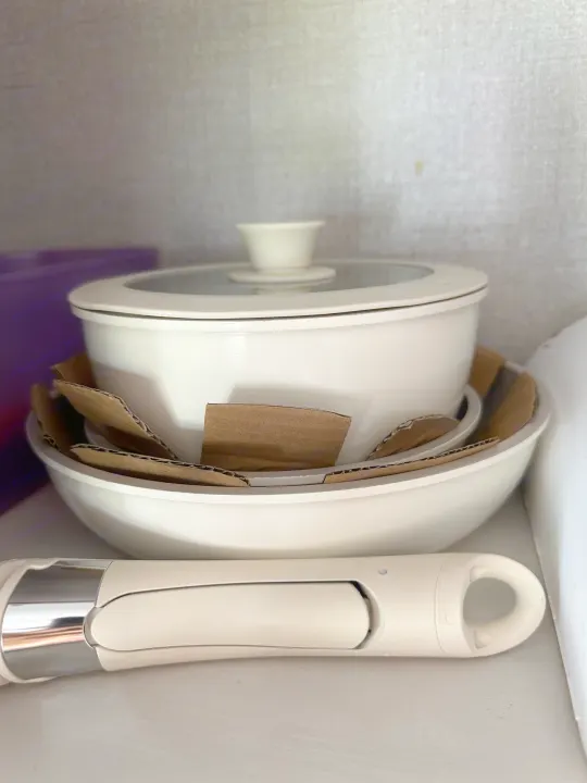 Compact white pots, bowls, and a kitchen utensil neatly stored for an RV rental. Perfect for travel cooking.. Highland Ridge RV Open Range 2022