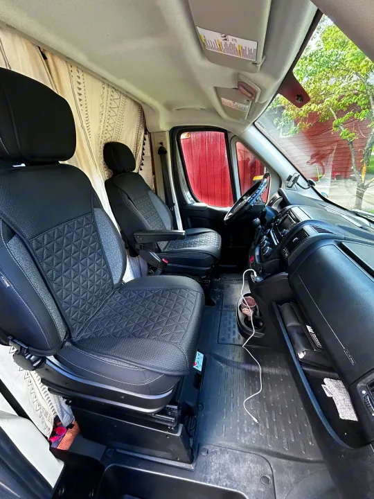Inside this RV rental: front cabin with quilted seats, dashboard, and patterned privacy curtains.. Dodge Ram 1500 2017