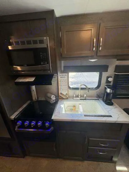 RV rental kitchen: microwave, stove, sink, and cabinetry. Fully equipped for your adventures!. Jayco Jay Flight SLX 2020