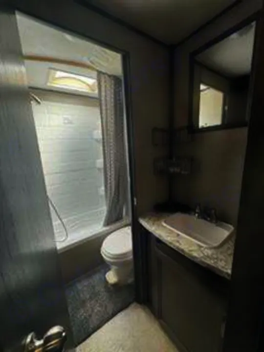 Inside a clean RV rental bathroom, showing a compact shower, toilet, and sink area.. Jayco Jay Flight SLX 2020