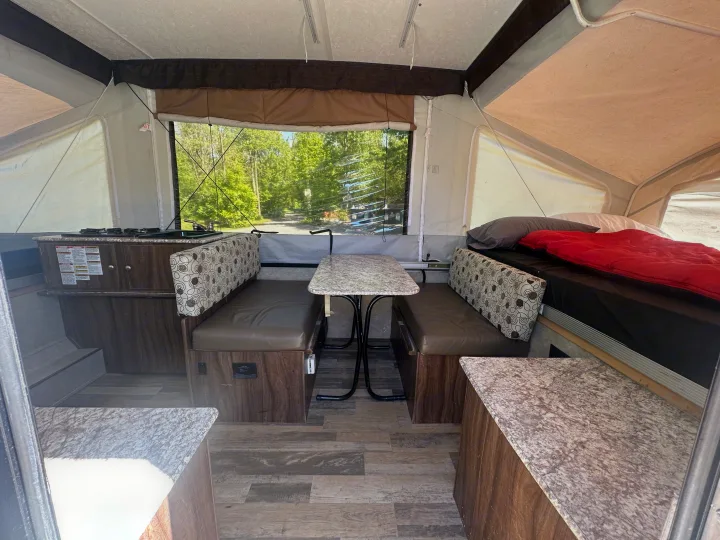 Compact RV rental interior: A bright space featuring a dinette, kitchen counter, and comfortable sleeping area.. coachmen clipper 2018