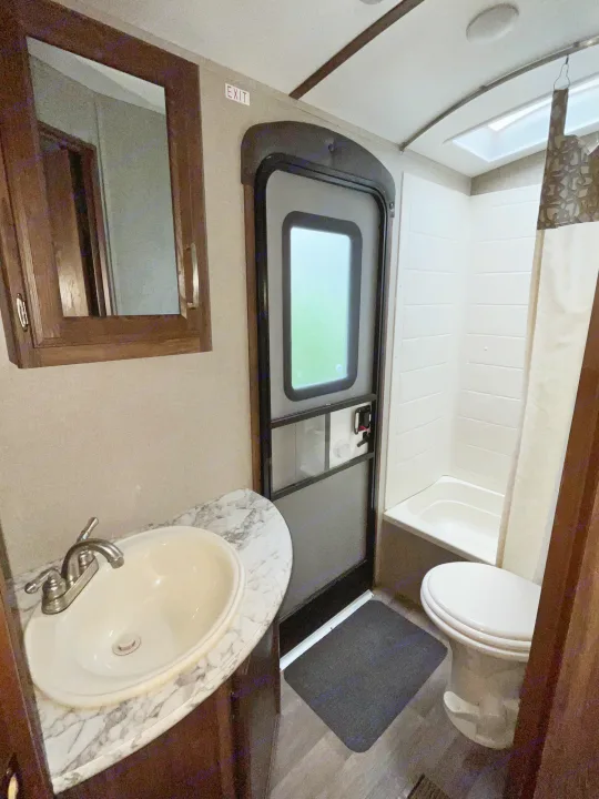 RV rental bathroom interior: sink, mirrored cabinet, toilet, and shower/tub combo with skylight. Compact and practical.. Keystone RV Cougar X-Lite 2018
