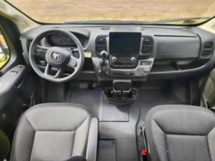 View of an RV rental's spacious front cabin, featuring a modern dashboard, large screen, steering wheel, and two comfortable front seats.. Winnebago Solis 2023