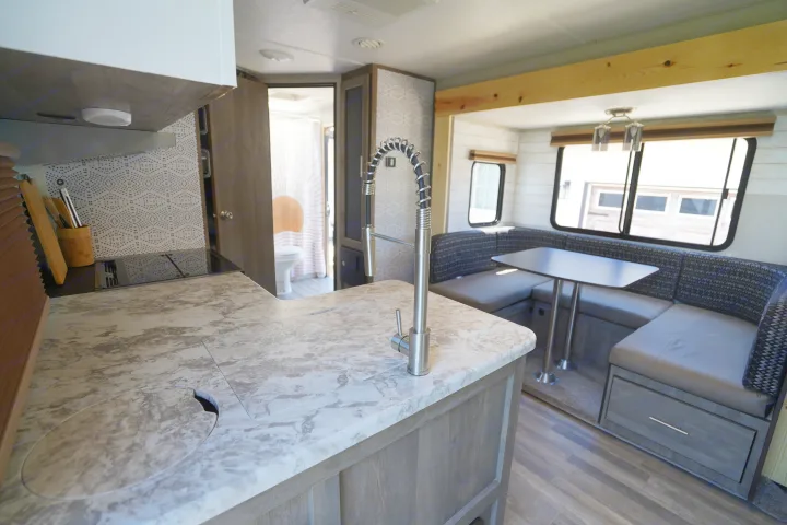 Explore this modern RV rental's kitchen, dinette, & bath area. Stylish & functional camper interior.. Forest River Vibe 2020