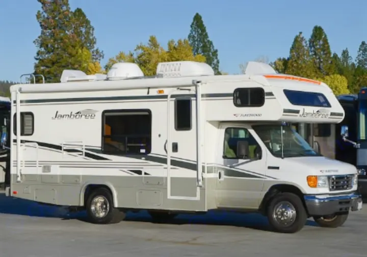 This white and grey Fleetwood Jamboree Class C RV rental is parked outdoors, ready for your next adventure. Perfect for travel.. Jamboree Jamboree Motorhome 2006