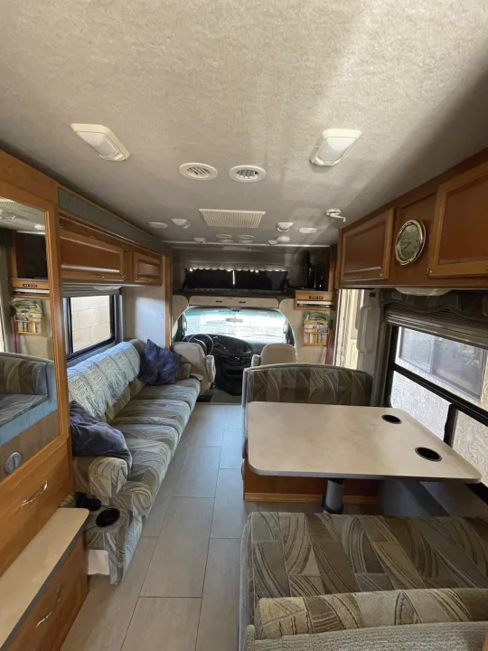 Spacious RV rental interior with couch, dinette, and front cab view.. Jamboree Jamboree Motorhome 2006