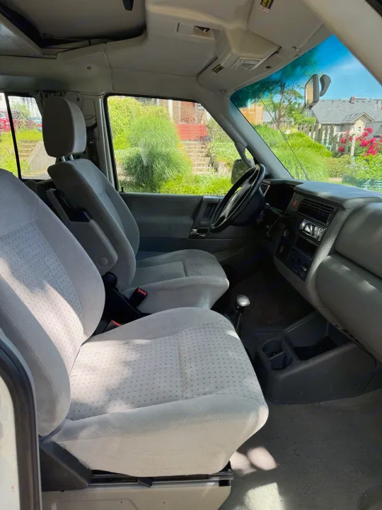 Spacious grey interior of a clean RV rental. Features front seats, manual shift, and dashboard. Perfect for road trips!. Volkswagen Westfalia 2003
