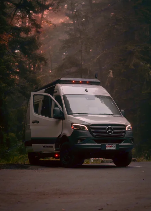 Misty forest RV rental: a white Mercedes camper van, door open, perfect for an off-grid nature adventure.. Winnebago Revel 2022