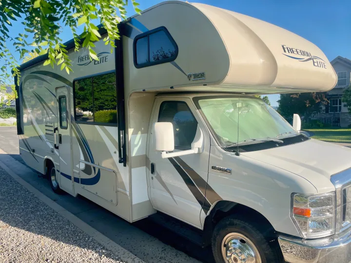 Explore with this Thor Freedom Elite Class C RV rental, parked curbside on a sunny day.. Thor Freedom Elite 2019