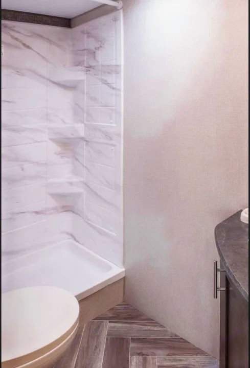 RV rental bathroom: modern, compact space with marble-look shower, wood-look floor, and sleek vanity. Clean design.. KZ Sportsmen SE 260BHSE 2020