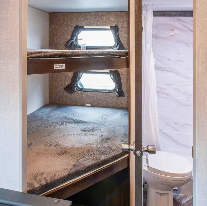 Spacious RV rental with cozy bunk beds (500 lbs capacity) and an adjacent modern bathroom with toilet.. KZ Sportsmen SE 260BHSE 2020