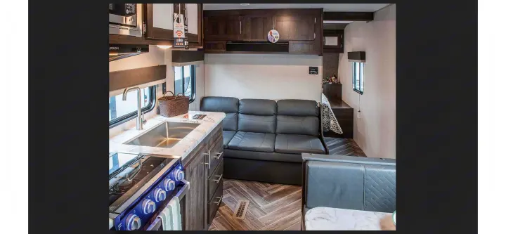 Spacious rv rental interior with a well-equipped kitchen, comfy sofa, and dining nook, ideal for travel adventures.. KZ Sportsmen SE 260BHSE 2020