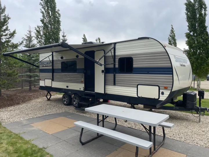 Spacious RV rental at a scenic campground, complete with an awning, patio, and picnic table for your leisure.. KZ Sportsmen SE 260BHSE 2020
