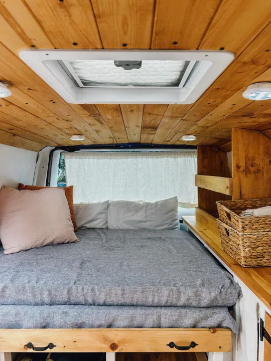Inside this inviting RV rental: a wooden ceiling, comfy bed, and practical built-in storage.. Gmc Safari 1996