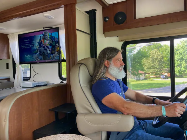 An RV rental journey begins, with a man at the wheel & Sea of Thieves on screen, blending travel & entertainment.. Georgetown GT3 2016