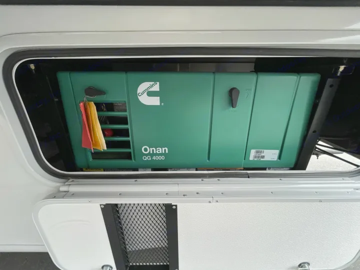 Inside an RV rental, a green Cummins Onan QG 4000 generator sits in its compartment, ready to power your adventure.. Thor ACE 2024