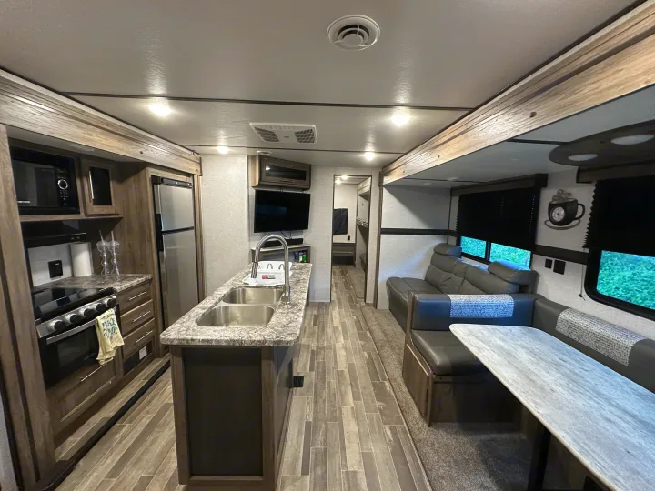 Spacious RV rental interior with modern kitchen, dining, and living areas, perfect for family travel.. Crossroads RV Zinger 2021