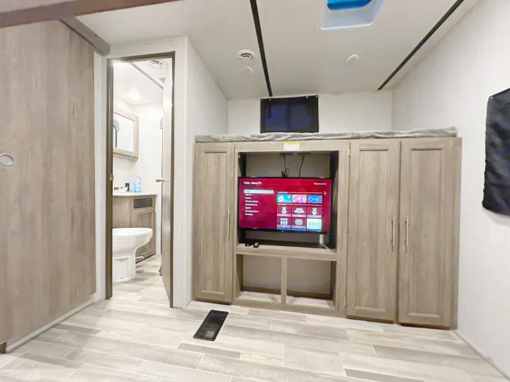 This RV rental's modern interior features a living area with TV and bunk bed, plus an accessible bathroom, ideal for family trips.. Crossroads RV Zinger 2021
